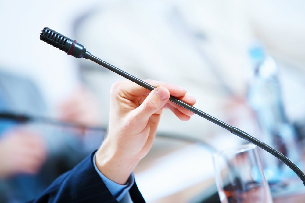 before a conference, the microphones in front of empty chairs.